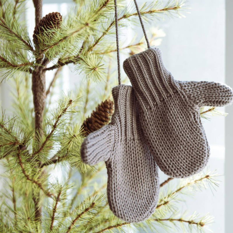Pair of gray cotton blend mittens hanging on a pine tree branch, adding a cozy touch to holiday decor, featured in Home & Decor and Holiday Decor collections.