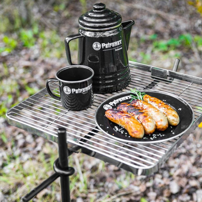 Black enamel camping plate with Petromax logo holding grilled sausages garnished with herbs, alongside a matching mug and coffee pot, ideal for Farm, Garden & Tool, Kitchen & Food, Camping, Dinnerware, and Best Sellers collections.