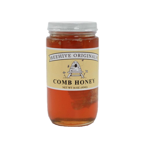 Clear glass jar of raw comb honey with visible honeycomb inside, featuring a beige label with rustic bee and hive illustration, made in USA, ideal for Kitchen & Food, Pantry, and Best Sellers collections.