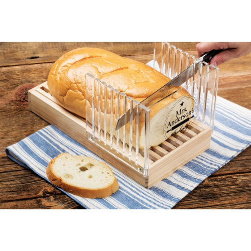 Handcrafted wooden bread slicing guide with clear acrylic panels for uniform slices, featuring a removable crumb tray, shown slicing a loaf on a striped kitchen towel in Kitchen & Food collections.