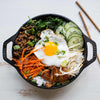 Handcrafted Lodge cast iron mini wok with flat bottom and loop handles, featuring a cooked dish with fried egg, ground meat, vegetables, and rice, part of Kitchen & Food and Cast Iron collections made in USA.
