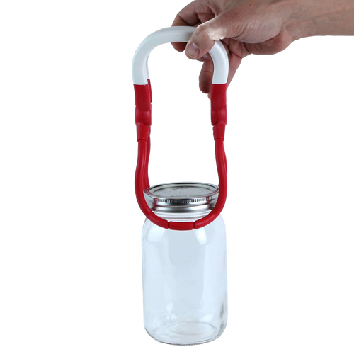 Hand lifting a clear glass canning jar with a metal lid using a red and white jar lifter tool, designed for safe handling during food preservation, ideal for Kitchen & Food and Canning collections.