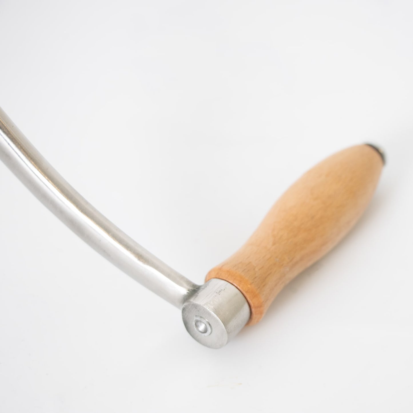 Close-up of a smooth wooden handle attached to a polished stainless steel crank arm, part of a handcrafted kitchen meat grinder featured in Specialty Equipment and Butchering Supplies collections.