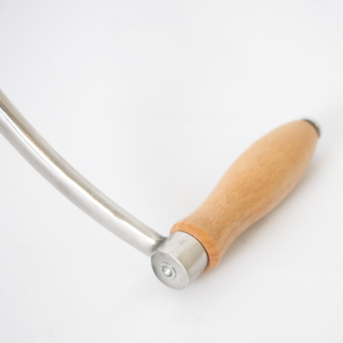 Close-up of a smooth wooden handle attached to a polished stainless steel crank arm, part of a handcrafted kitchen meat grinder featured in Specialty Equipment and Butchering Supplies collections.