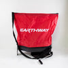 Red nylon seed spreader bag with adjustable black shoulder strap and crank handle, featuring heavy-duty enclosed nylon gears, made in USA for Farm, Garden & Tool and Seeds and Planting collections.