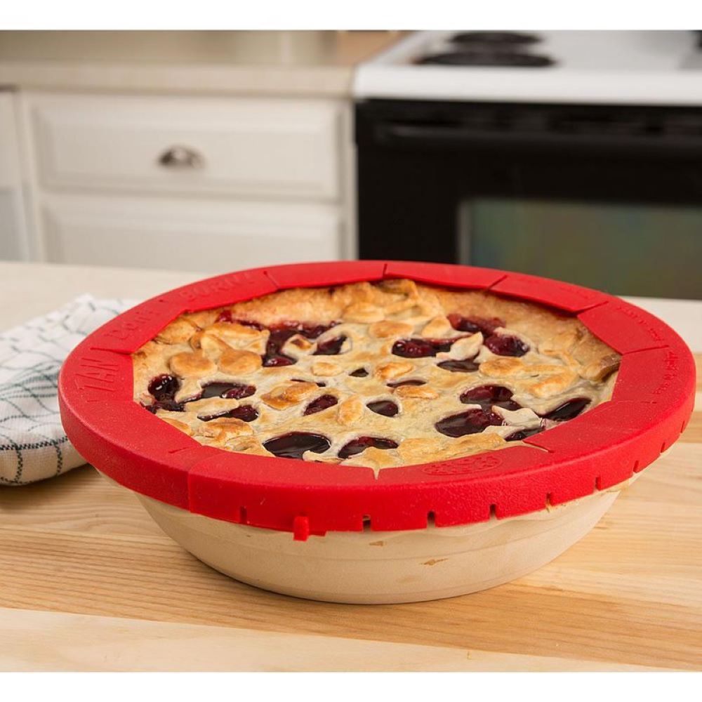 Freshly baked pie with a golden crust protected by a red silicone pie crust shield, designed to prevent burning and fit various pie sizes, featured in Kitchen & Food and Baking Supplies collections.