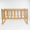 Handcrafted solid oak doll cradle with smooth finish and classic slatted design, made in the USA by Amish artisans for children's indoor play and doll accessories collections.