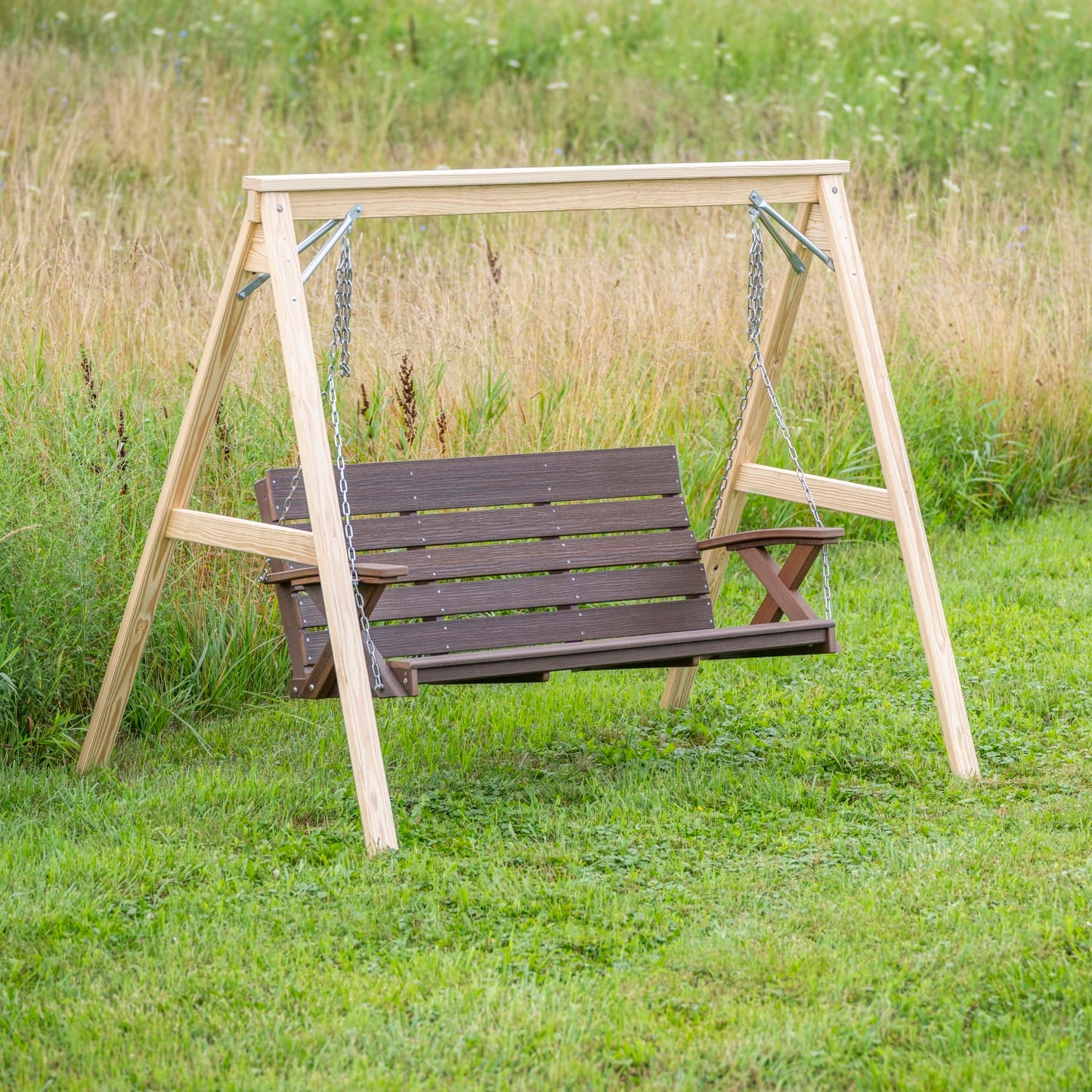 Handcrafted Amish made A-frame stand in natural wood finish supporting a dark brown hanging porch swing, set outdoors on green grass; featured in Home & Decor and Outdoor Furniture collections.