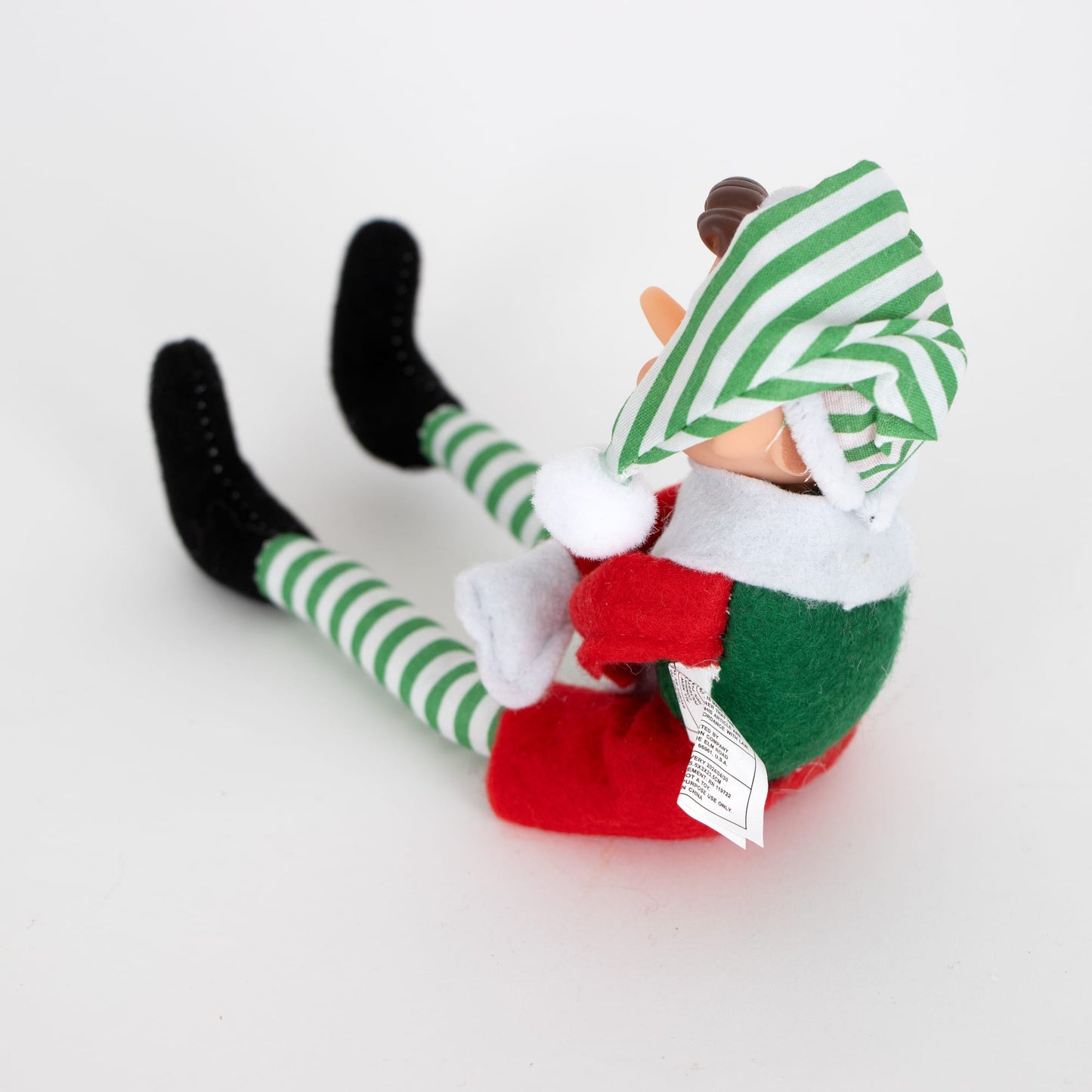 Posable retro-style Christmas elf ornament in green and red fabric with striped green and white tights and a matching hat, perfect for Home & Decor and Holiday Decor collections.