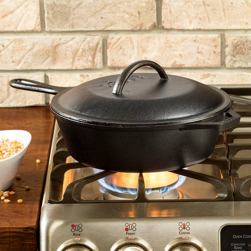 Black cast iron chicken fryer with lid featuring self-basting nubs heating on a stovetop burner, ideal for even cooking and heat retention in Kitchen & Food and Cookware collections.