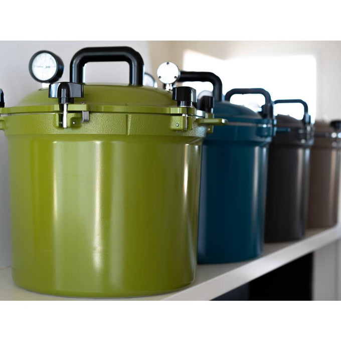 Row of colorful metal pressure canners featuring secure locking lids and pressure gauges, ideal for safe food preservation in Kitchen & Food, Canning, and USA Made collections.