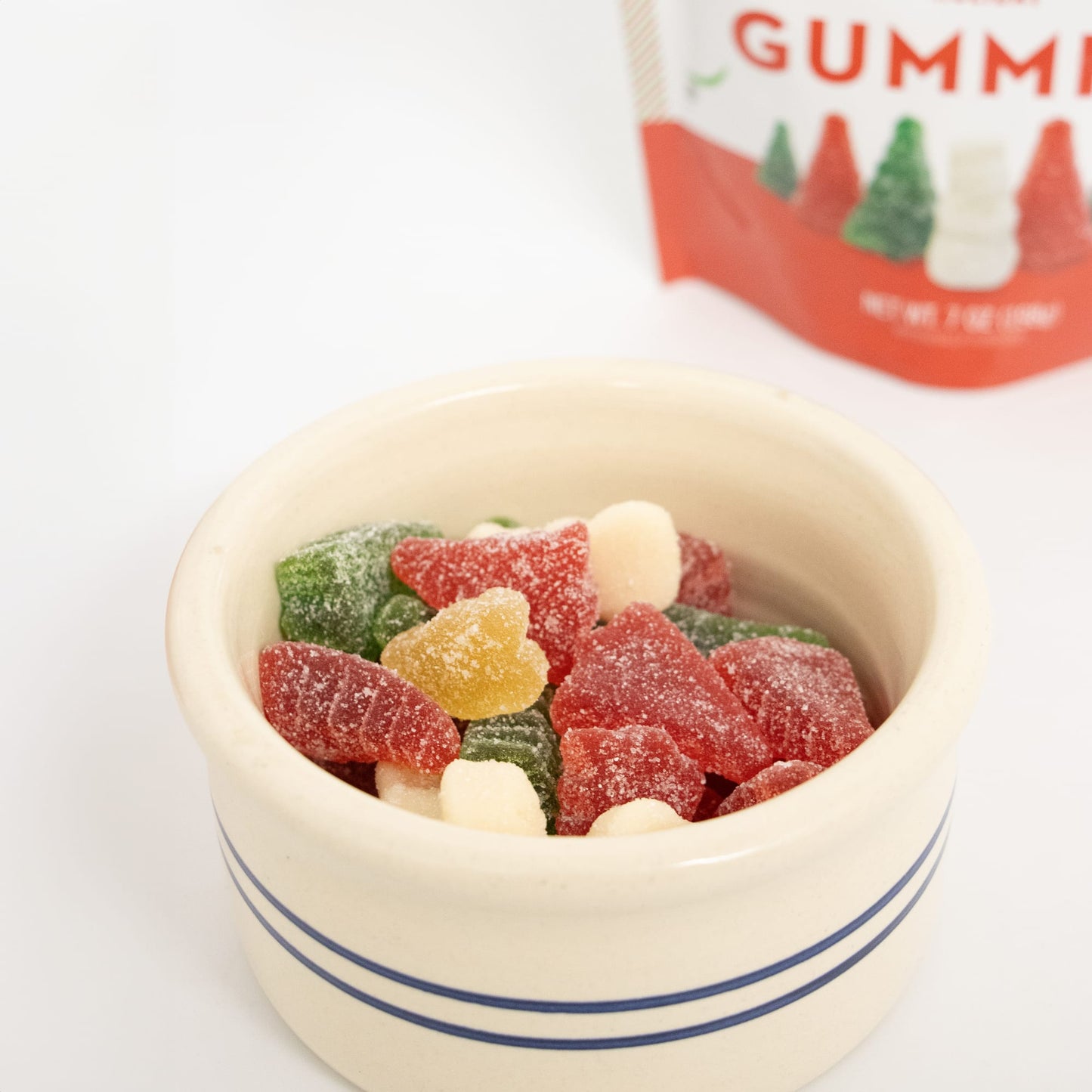 Handmade red, green, and white sugar-coated Christmas gummies shaped like trees and snowmen in a cream ceramic bowl, part of Kitchen & Food, Candy, USA Made, and Best Sellers collections.