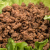 Close-up of handcrafted fully cooked canned ground beef on fresh green lettuce, highlighting its natural quality, ideal for Kitchen & Food, Food, Meats, Best Sellers, and Promo Eligible collections.