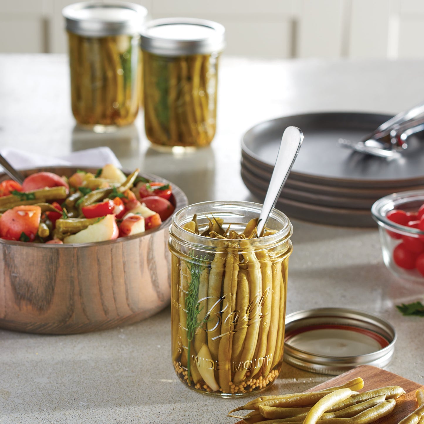 Clear glass wide-mouth pint jar handcrafted in the USA, filled with pickled green beans, shown with metal lid and spoon, ideal for Kitchen & Food, Food Preservation, and Canning collections.
