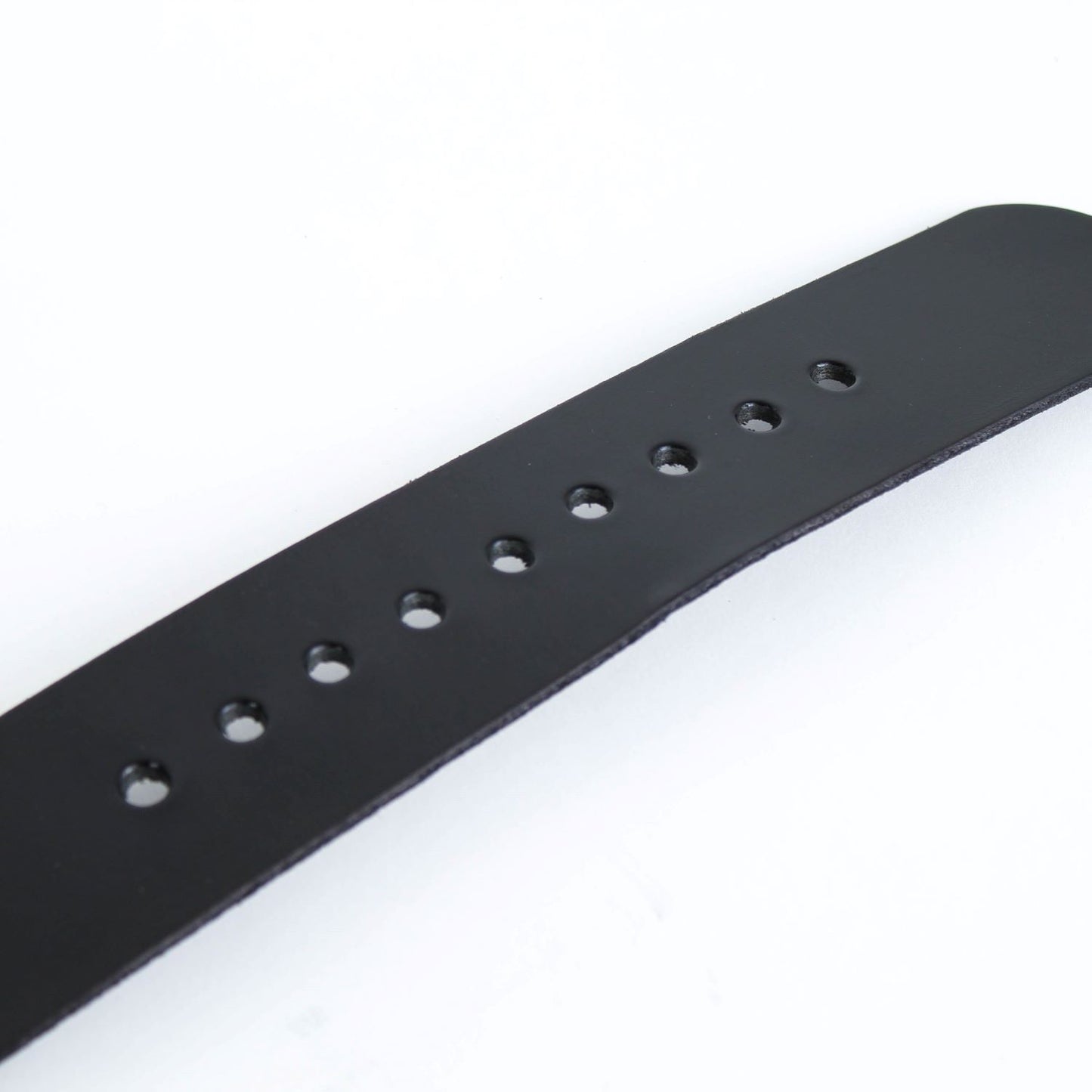 Close-up of a handmade black leather belt strip with evenly spaced holes, featuring genuine cowhide, crafted in the USA and part of Health & Wellness, USA Made, Amish Made, and Best Sellers collections.