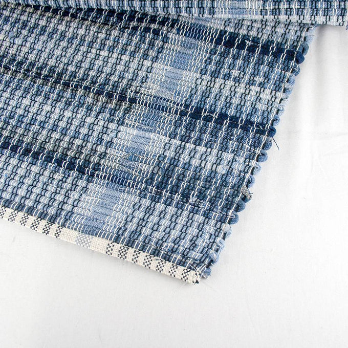 Close-up of a handwoven blue denim rug with a textured plaid pattern and finished edge, showcasing durable craftsmanship in Home & Decor and USA Made collections.