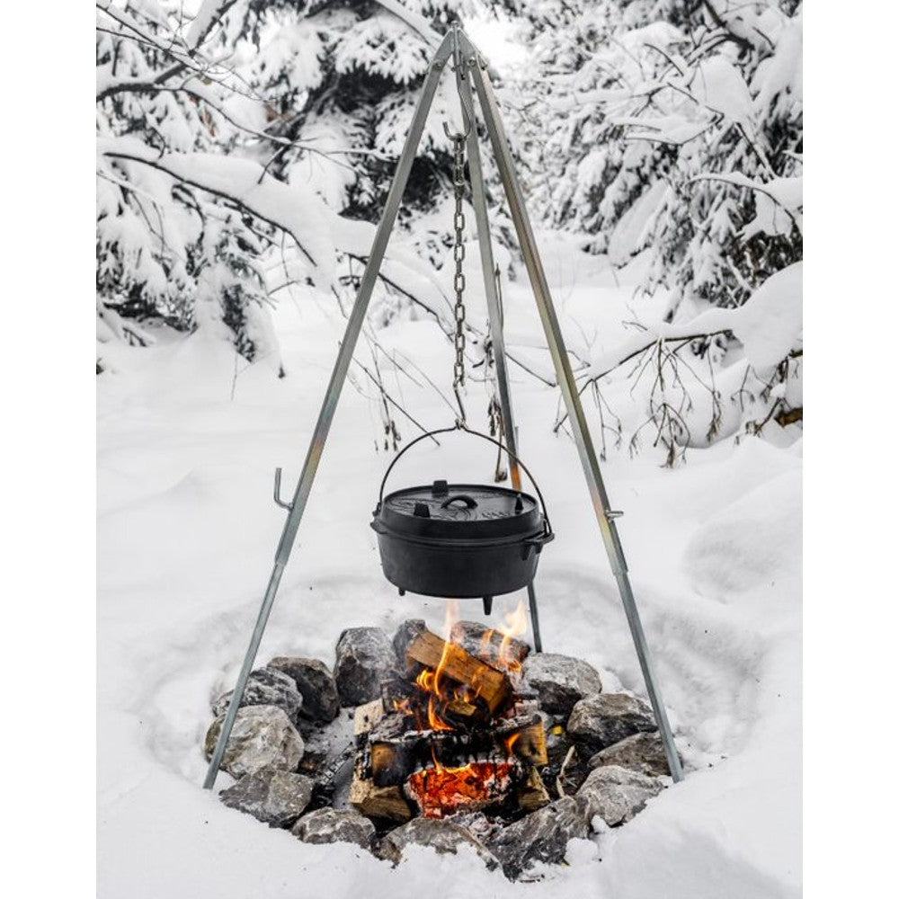 Metal tripod with adjustable chain suspending a cast iron Dutch oven over a burning wood fire pit surrounded by snow, ideal for Farm, Garden & Tool, Camping, Best Sellers, and Promo Eligible collections.