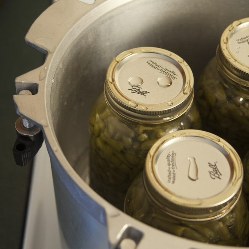 Close-up of glass canning jars filled with green beans inside a heavy-duty metal pressure canner, highlighting safe food preservation in Farm, Garden & Tool and Kitchen & Food collections.
