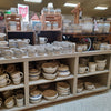 Shelves filled with handcrafted stoneware crocks, mugs, bowls, and pitchers in neutral tones, perfect for Kitchen & Food, Food Preservation, and USA Made collections.