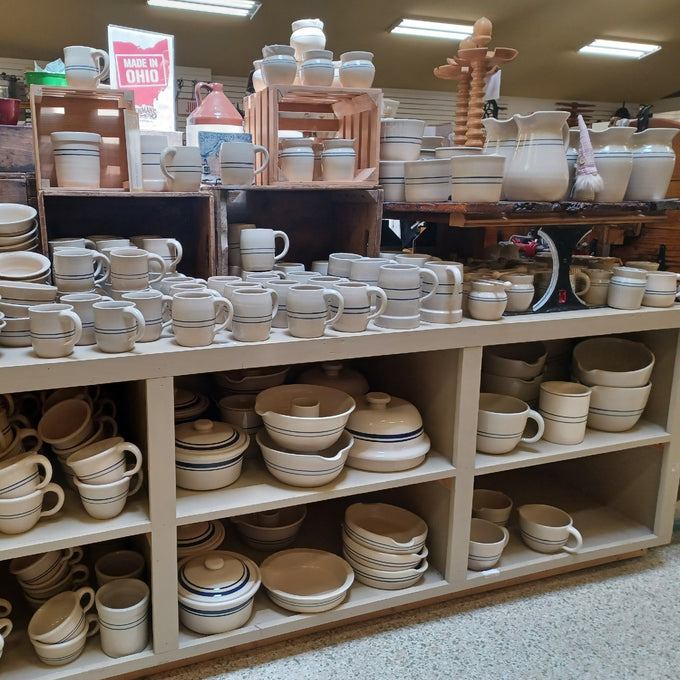 Shelves filled with handcrafted stoneware crocks, mugs, bowls, and pitchers in neutral tones, perfect for Kitchen & Food, Food Preservation, and USA Made collections.