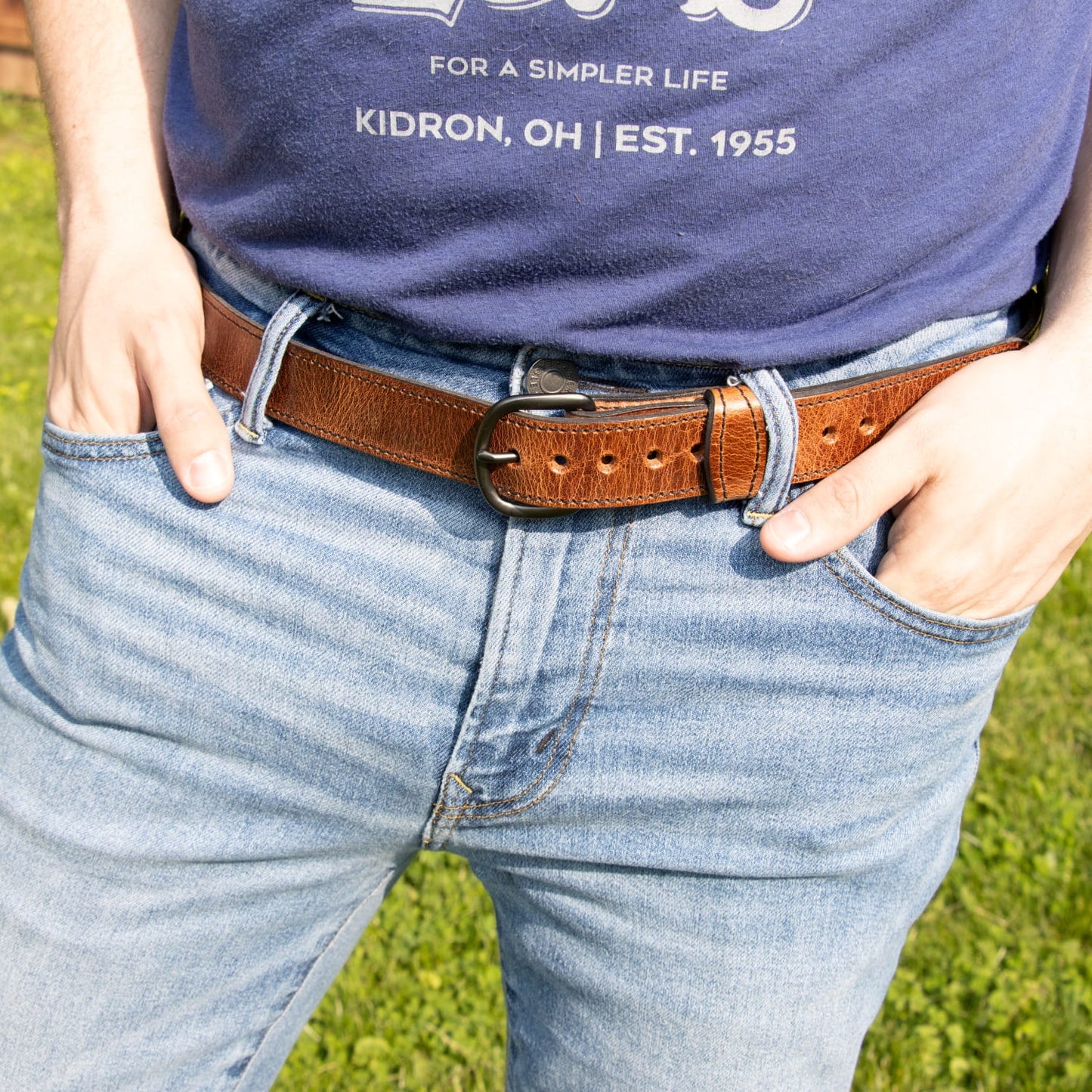Close-up of a handcrafted Amish-made brown leather dress belt with sturdy buckle, worn with jeans, featured in Clothing and Accessories, USA Made, Amish Made, and Best Sellers collections.