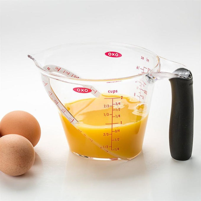 Clear plastic measuring cup with angled red measurement markings up to 2 cups, soft black grip handle, filled with beaten eggs, suitable for Kitchen & Food, Food Prep, Measuring, and Best Sellers collections.