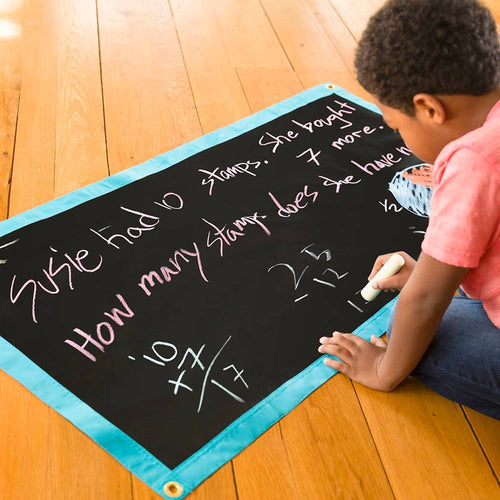 Child drawing math problems on a portable black chalk mat with blue trim, designed for indoor play and educational activities in Toys, Children's Toys, and Indoor Play collections.