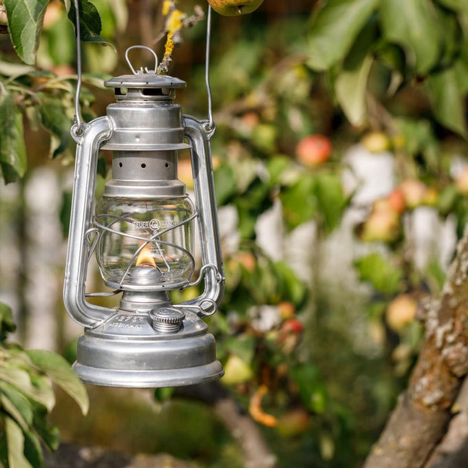 Unique handcrafted galvanized oil lantern with thermal heat-resistant globe, glowing warmly while hanging outdoors among green leaves and apples in Camping, Lamps & Lighting, and Emergency Supplies collections.