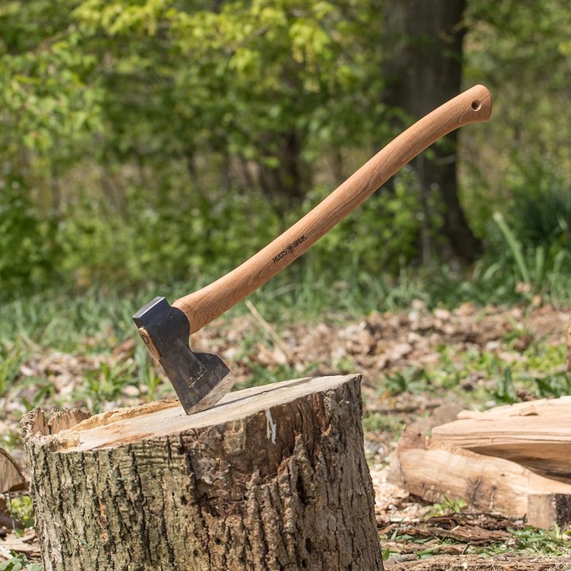 Hand-forged axe with a curved American hickory handle and single bit Swedish steel head embedded in a tree stump, ideal for Farm, Garden & Tool and Wood Cutting and Hauling collections.