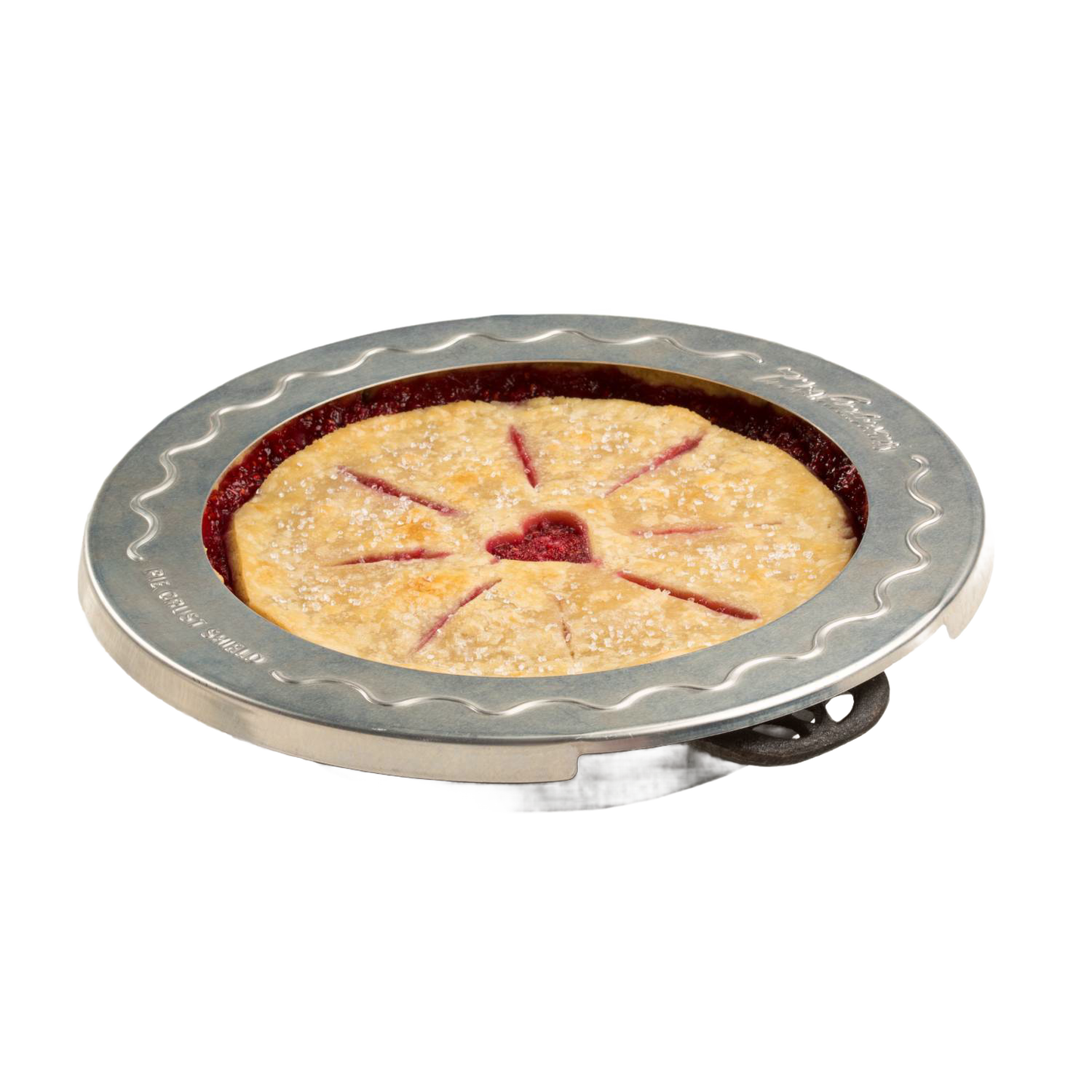 Aluminum pie crust shield placed around the edges of a golden brown pie with decorative slits and a heart-shaped center cutout, protecting the crust from burning during baking.