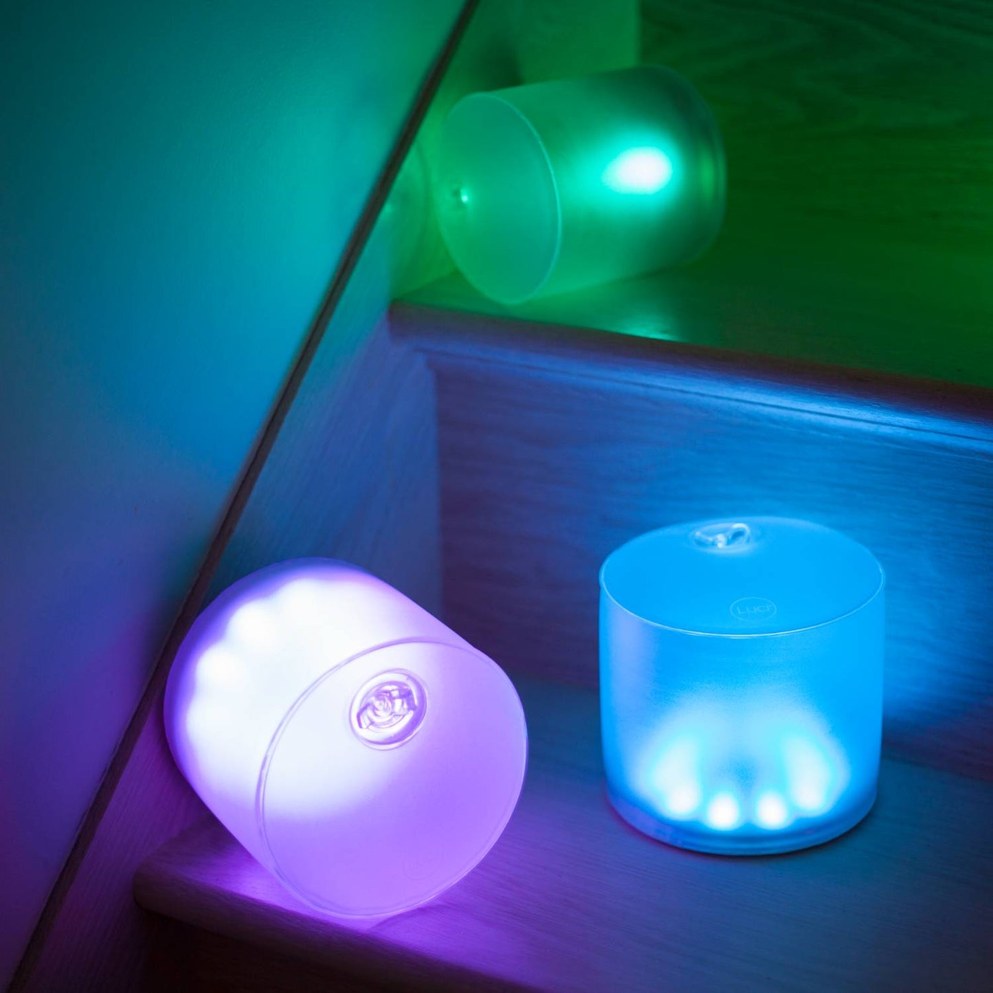 Three handcrafted inflatable LED solar lights glowing in soothing shades of blue, teal, and purple, ideal for camping, emergency supplies, and outdoor farm and garden lighting.
