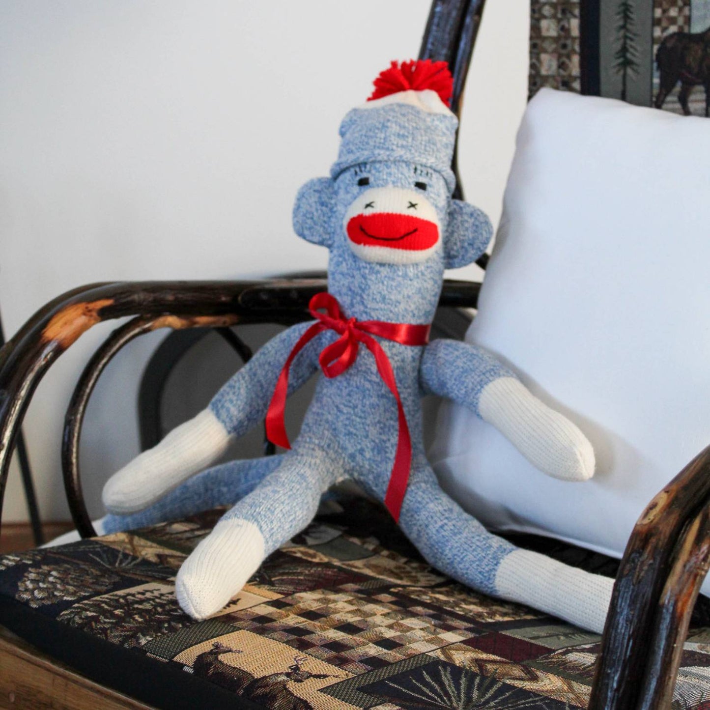 Hand-sewn sock monkey made in USA from classic red and white heel socks with a blue knitted body, red pom-pom hat, and red ribbon bow, featured in Toys, Books & Games and Children's Toys collections.