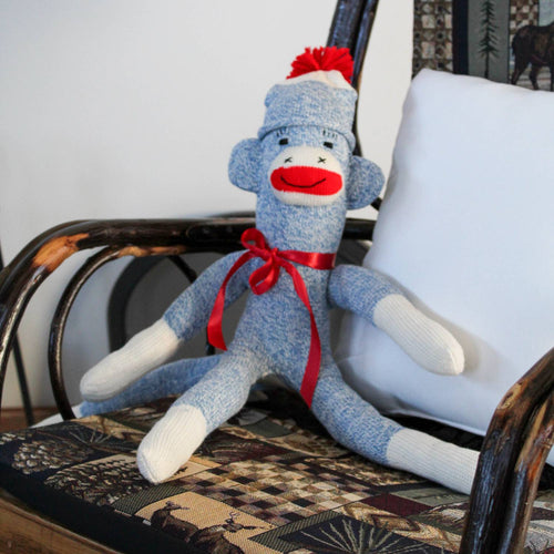 Hand-sewn sock monkey made in USA from classic red and white heel socks with a blue knitted body, red pom-pom hat, and red ribbon bow, featured in Toys, Books & Games and Children's Toys collections.