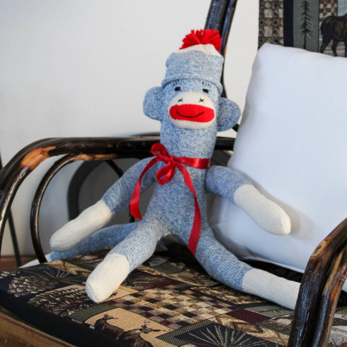 Hand-sewn sock monkey made in USA from classic red and white heel socks with a blue knitted body, red pom-pom hat, and red ribbon bow, featured in Toys, Books & Games and Children's Toys collections.