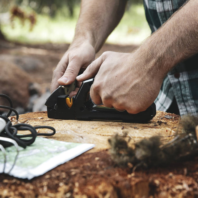 Person using a handheld sharpener on a tree stump outdoors, designed for quickly restoring knives and garden tools, featured in Farm, Garden & Tool, Hand Tools and Hardware, and Sharpening collections.