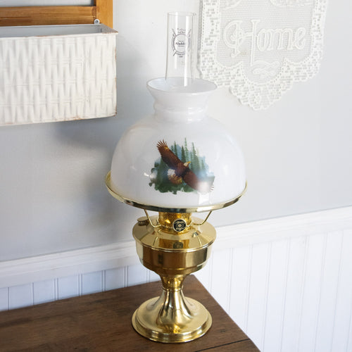 Handcrafted white glass lamp shade featuring a soaring eagle design over pine trees paired with a polished brass oil lamp base, ideal for Lamps & Lighting and Parts and Accessories collections.