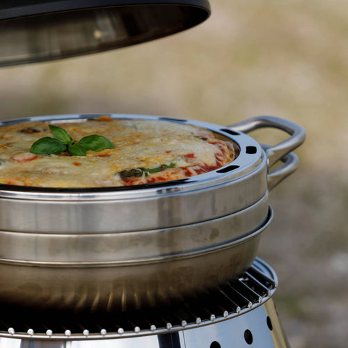 Close-up of a handcrafted stainless steel camping oven baking a golden casserole topped with fresh basil, designed for outdoor use in Farm, Garden & Tool and Camping collections.