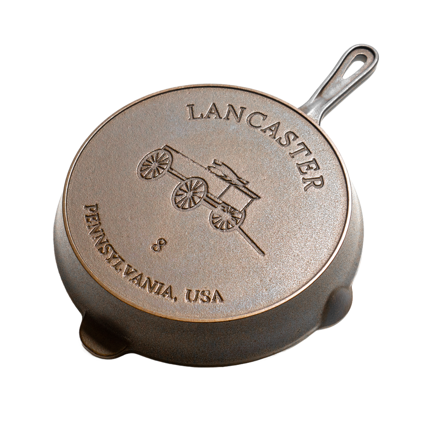Bottom view of a handcrafted, lightweight cast iron skillet with embossed design of a horse-drawn wagon and the text Pennsylvania, USA, suitable for Kitchen & Food, Cast Iron, and USA Made collections.