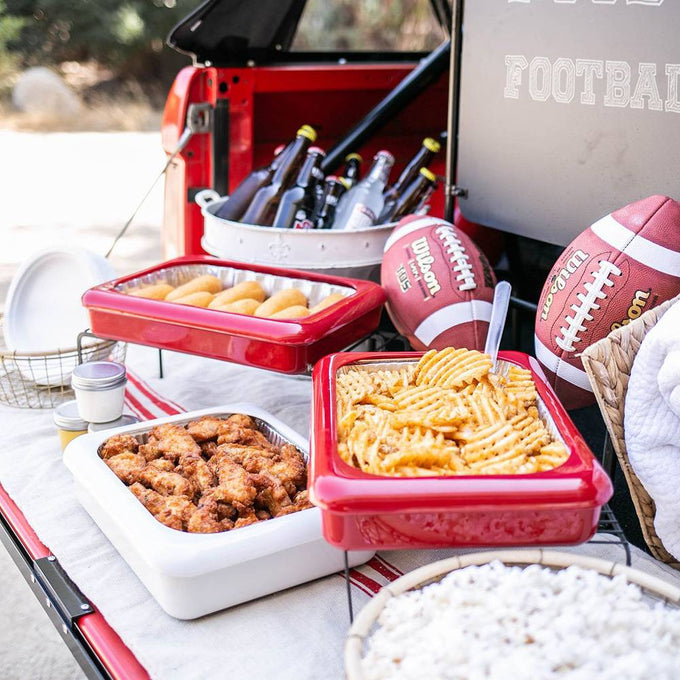Red and white ceramic serving dishes filled with fried chicken, crinkle-cut fries, and corn dogs set on a picnic table near footballs and drinks, featured in Kitchen & Food and Storage collections.