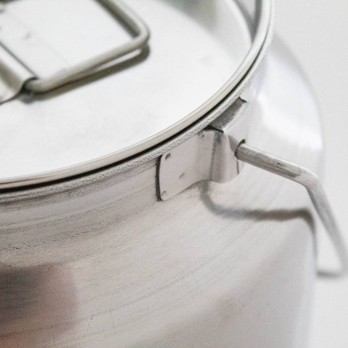 Close-up of a seamless small stainless steel milk can with sturdy handle and secure lid, crafted from shining 304 grade steel, ideal for farm, garden, and animal care use.