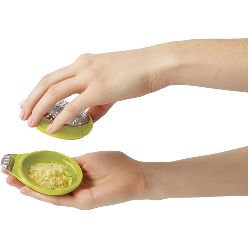 Hands holding a lime-green ergonomic citrus zester with stainless steel blade and channel knife, showcasing freshly grated zest for Kitchen & Food, Cooking Helpers, and Best Sellers collections.