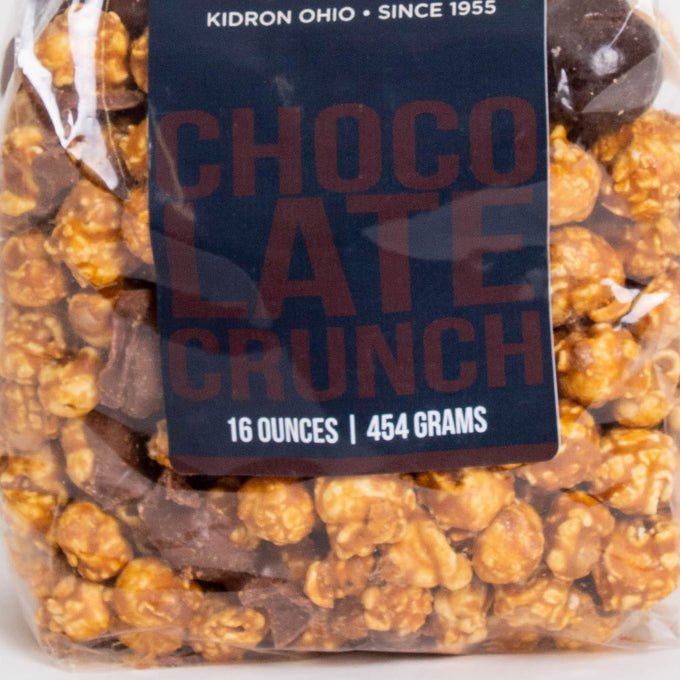 Clear bag of handcrafted caramel popcorn with rich chocolate crunch pieces, a unique sweet and crunchy snack made in USA, featured in Kitchen & Food, Snacks and Sweets, Popcorn, USA Made, and Best Sellers collections.