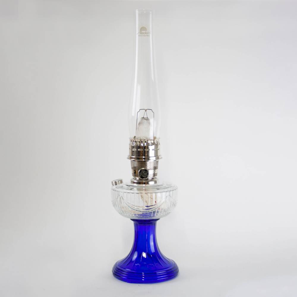 Handcrafted oil lamp with a distinctive clear glass font and vibrant cobalt base, featuring brass trim and classic drape design, perfect for Lamps & Lighting, Oil Lamps, Table Lamps, Best Sellers, and Promo Eligible collections.