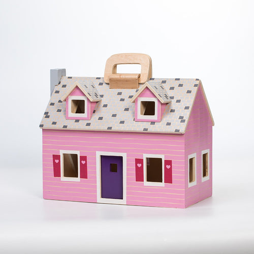 Pink wooden foldable dollhouse with purple door, gray shingled roof, and wooden handle, featuring small cutout windows with red shutters, designed for children's indoor play collections.