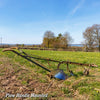 Rustic farming plow with Amish-made hardwood handles mounted on a metal cultivator frame, set in a bright rural field, featured in Farm, Garden & Tool and Digging and Cultivating collections.