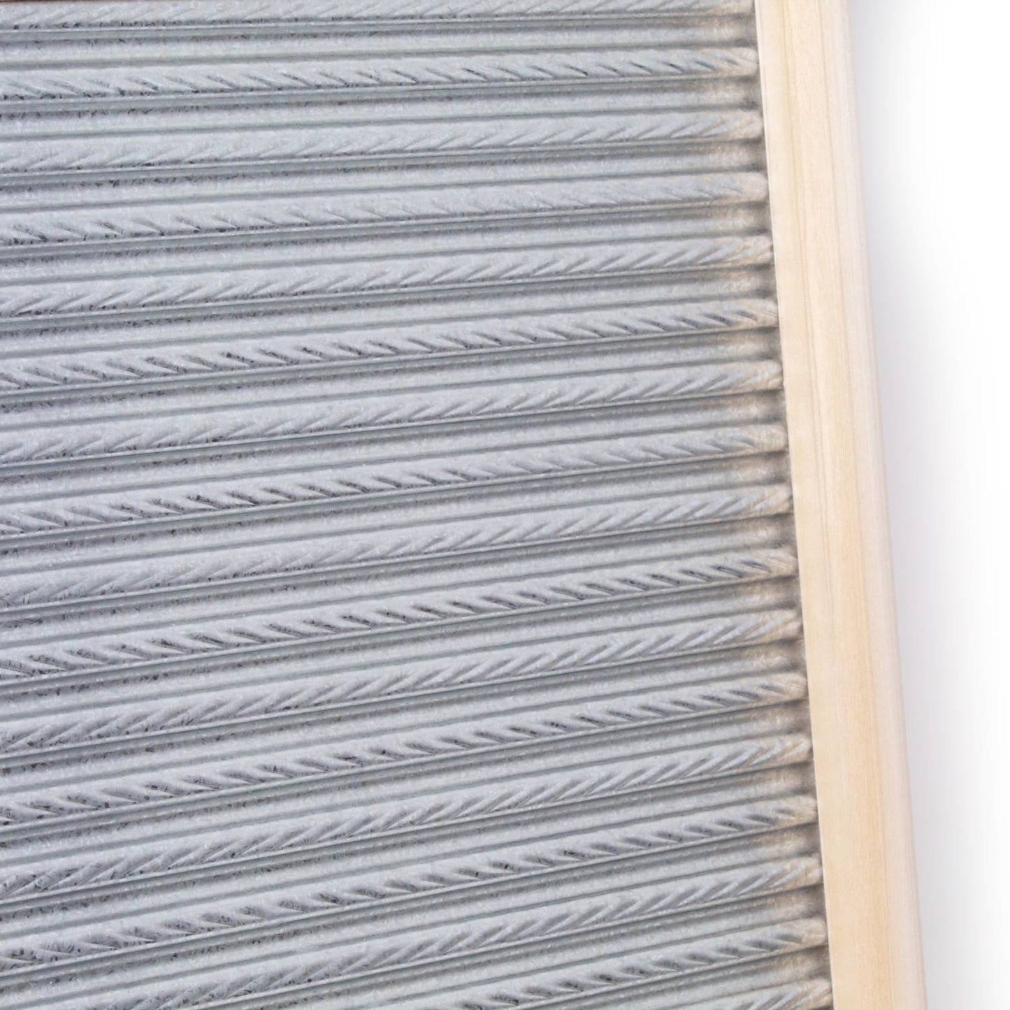 Handcrafted galvanized metal washboard with spiral crimp design and light wooden frame, designed for effective stain removal in laundry supplies, made in USA.