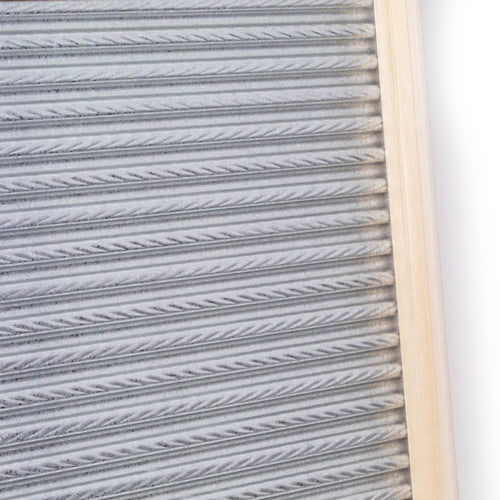 Handcrafted galvanized metal washboard with spiral crimp design and light wooden frame, designed for effective stain removal in laundry supplies, made in USA.