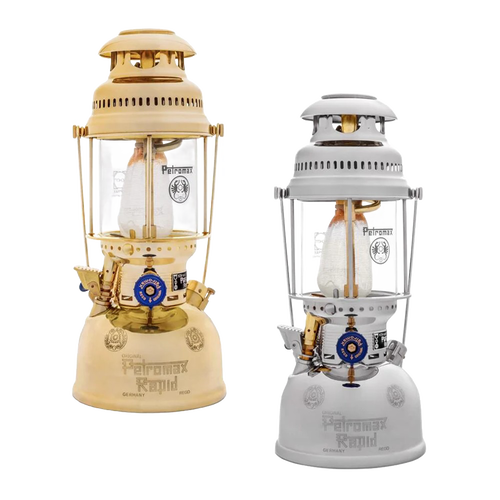 Two classic kerosene pressure lamps in beige and white finishes, featuring glass chimneys and brass details, designed for durable outdoor lighting in camping and emergency supplies collections.