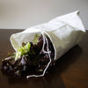 Reusable white fabric storage bag with drawstring closure containing fresh green and red lettuce, designed to help keep produce crisp, featured in Kitchen & Food and Storage collections.