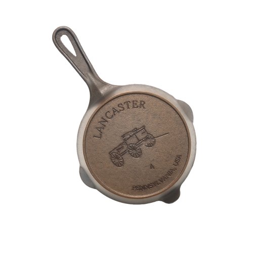 Handcrafted lightweight cast iron skillet with smooth surface, featuring a vintage wagon design embossed on the base, made in USA, ideal for Kitchen & Food, Camping, and Cast Iron collections.